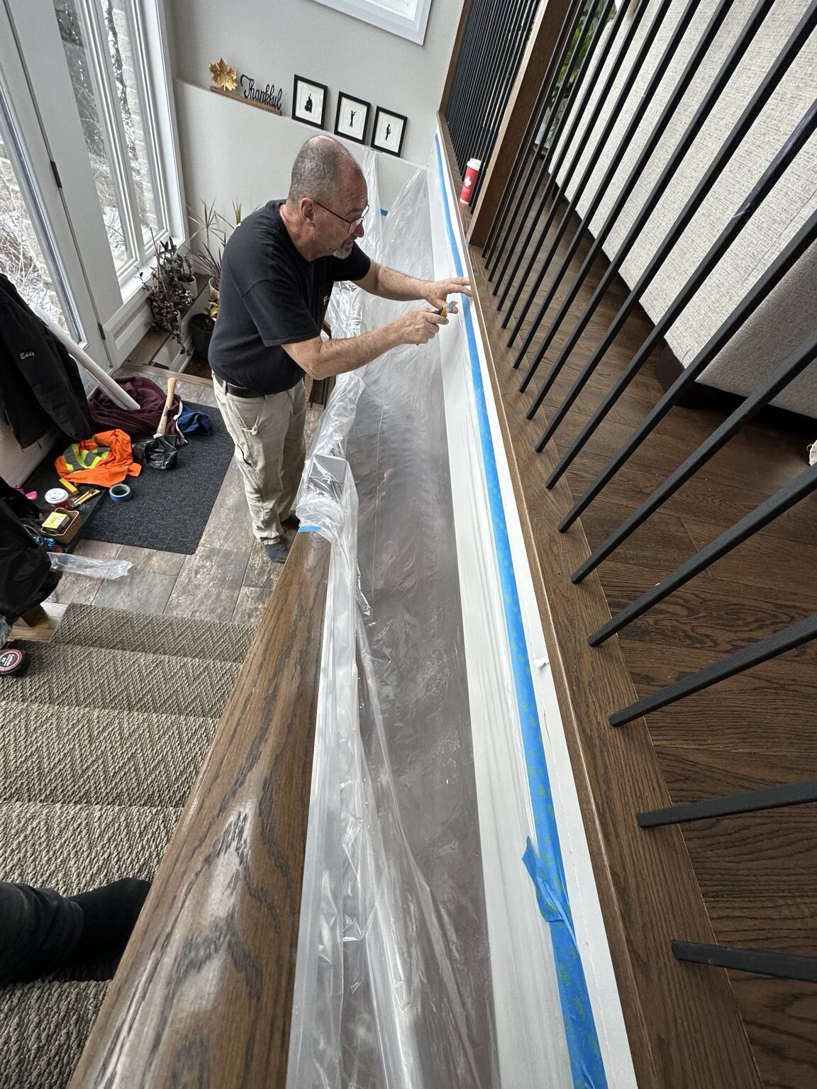 Carpenter strengthening a long interior stair railing